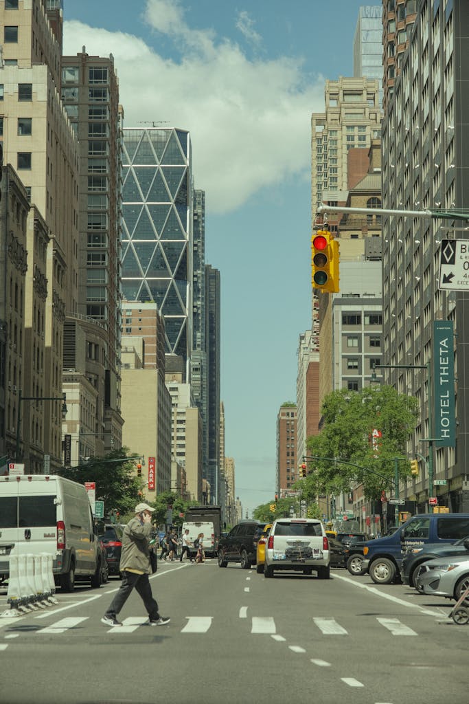 A man crossing the street in front of tall buildings